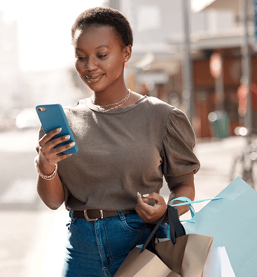 black woman holding a phone and some shopping bags