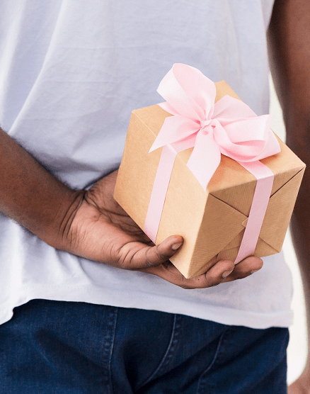 man hiding gift behind his back